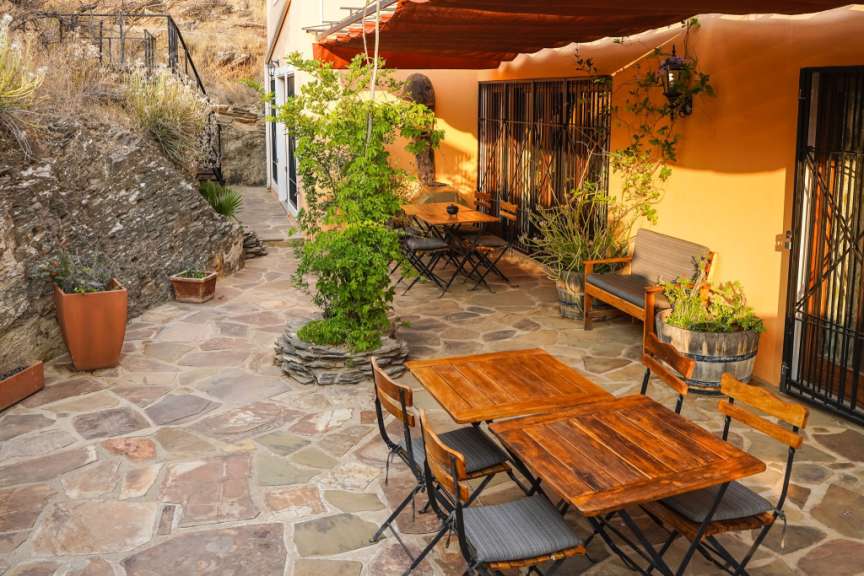 Eine Terrasse mit Holztischen und Stühlen und einem Dach