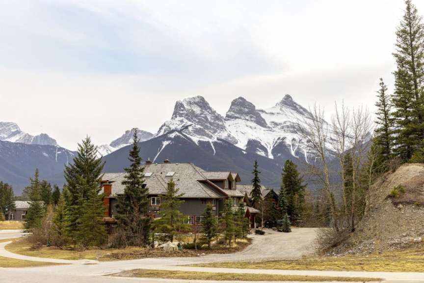 Ein großes Haus steht auf einem Hügel mit Bergen im Hintergrund