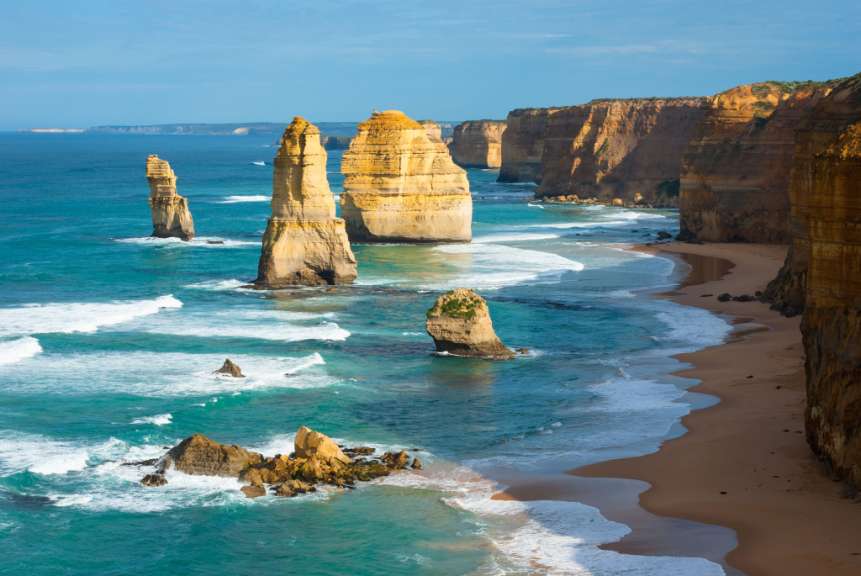Das Bild zeigt eine Küstenlandschaft mit den Felsformationen „Zwölf Apostel“ und dem Great Ocean Walk in Australien.