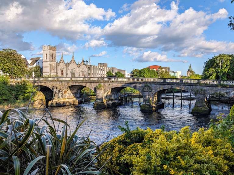 Eine Brücke über einen Fluss mit einer Kirche im Hintergrund