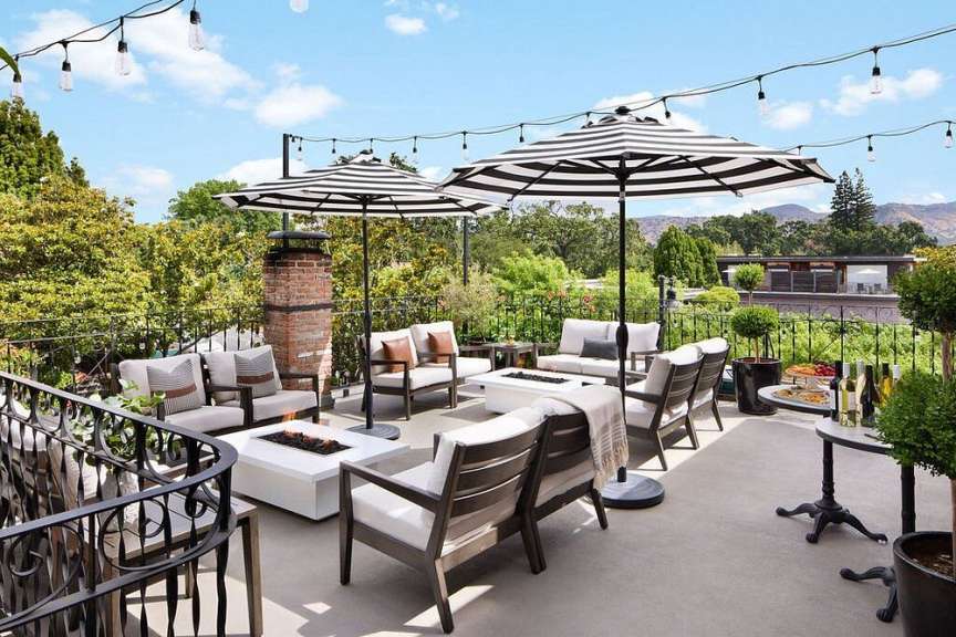 Eine Terrasse mit Möbeln und schwarz-weißen Regenschirmen