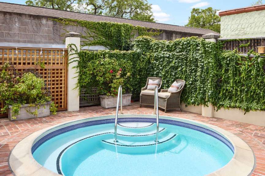 Ein kleiner Pool mit Treppe und Stühlen davor