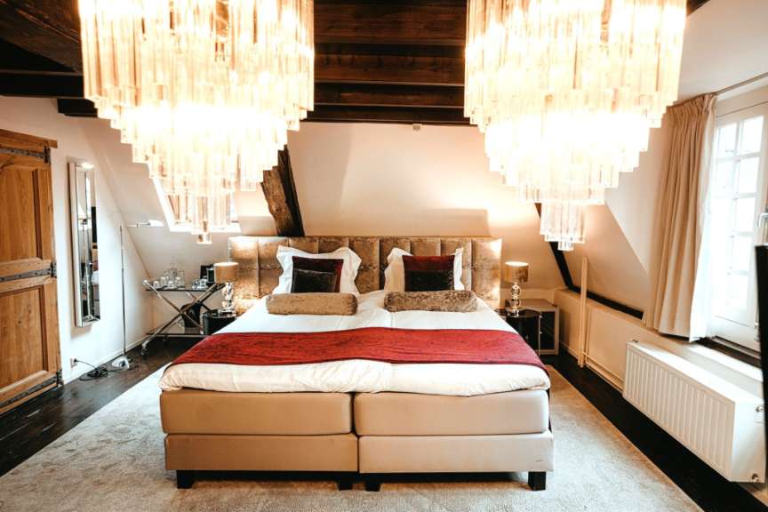 Ein Schlafzimmer mit einem Bett und zwei Kronleuchtern