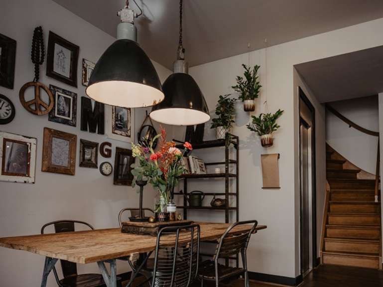 Ein Esszimmer mit einem Tisch und Stühlen und Bildern an der Wand