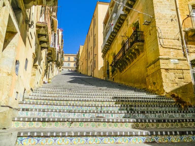 Eine Treppe führt hinunter zu einer Straße mit einem Schild darauf