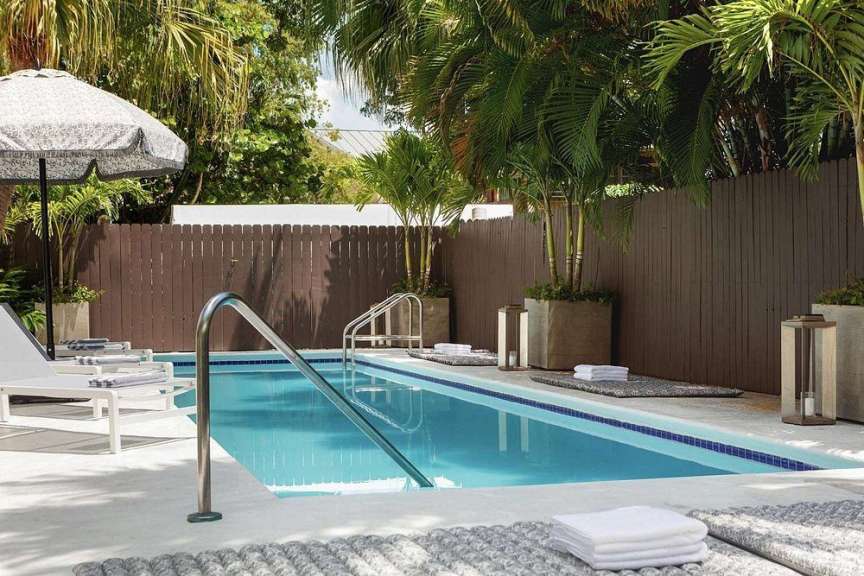 Ein Swimmingpool mit Handtüchern und Sonnenschirmen umgeben