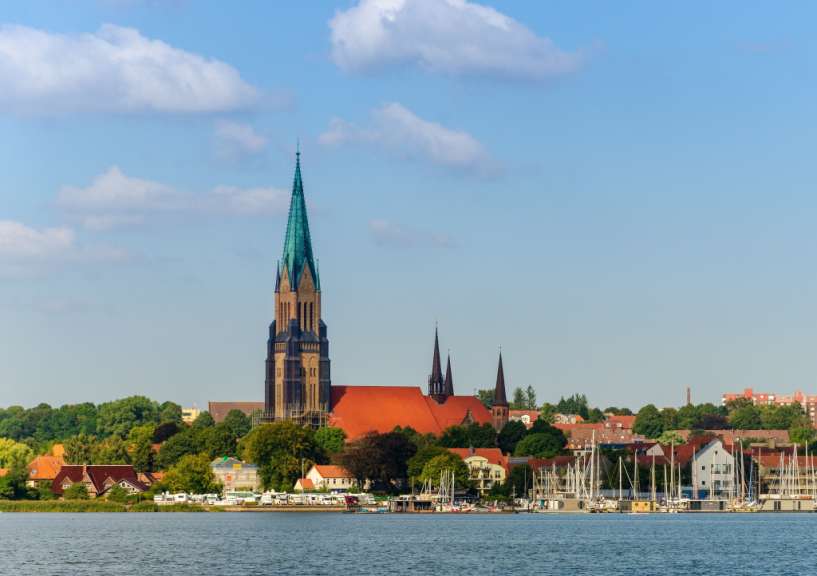 Eine Stadt mit vielen Gebäuden und einem großen Wasserkörper im Vordergrund