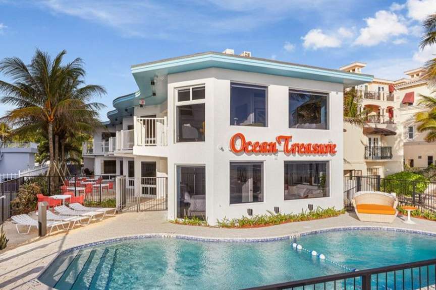 Ein weißes Gebäude mit einem Pool und der Aufschrift „ ocean treasure “