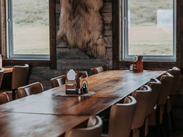 Ein langer Holztisch mit Stühlen in einem Restaurant