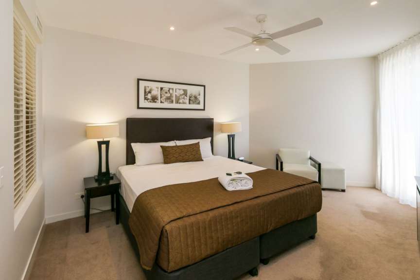 Ein Schlafzimmer mit einem Bett und einem Deckenventilator