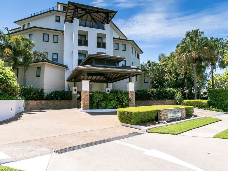 Ein großes weißes Gebäude mit einem Schild davor, das sagt ‚ paradise ‘