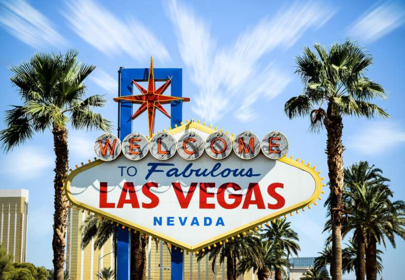 Ein Willkommensschild in Las Vegas mit Palmen im Hintergrund