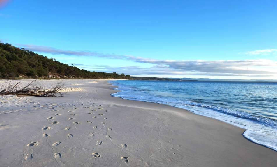Ein Strand mit Füßenspuren im Sand