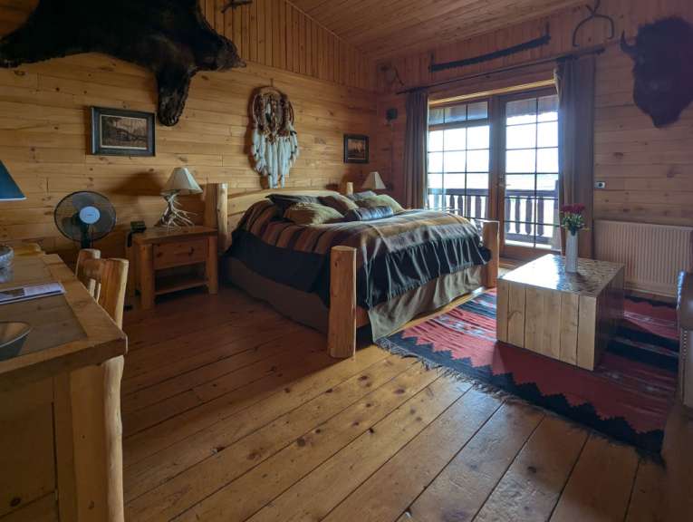 Ein Holzzimmer mit einem Bett und einem Tisch
