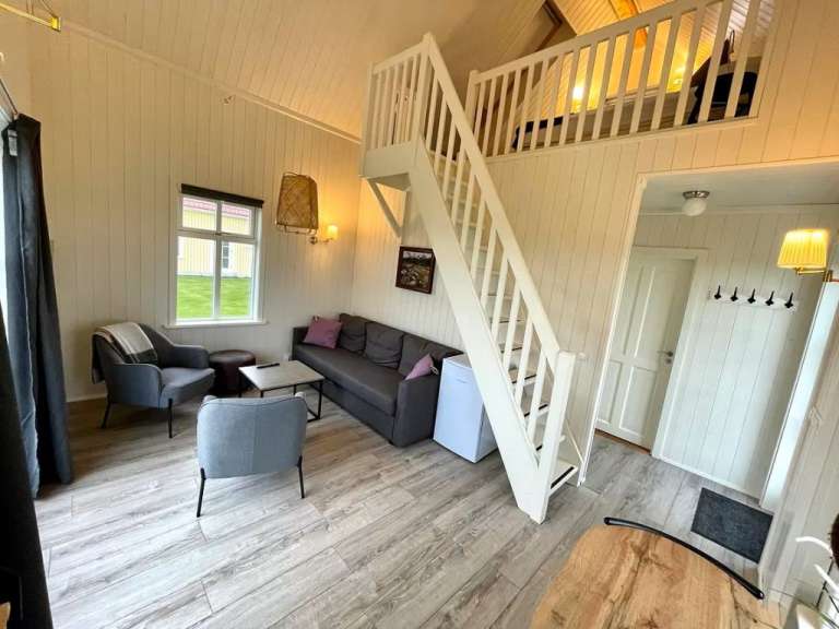 Ein Wohnzimmer mit einer Treppe zum Dachboden