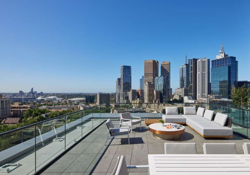 Ein Balkon mit einer Couch und Stühlen und einem Tisch