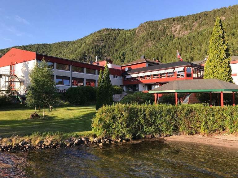 Ein großes rot-weißes Gebäude steht neben einem See