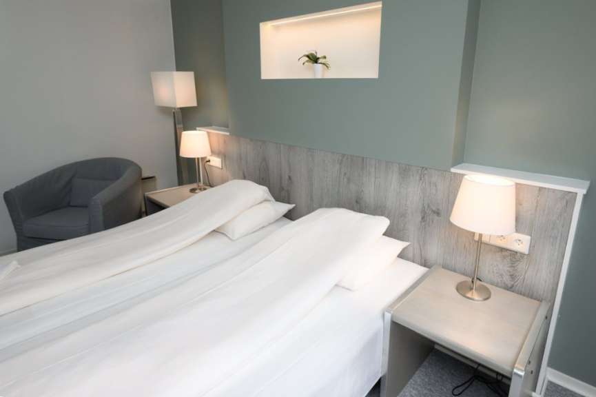 Ein Hotelzimmer mit einem Bett und zwei Lampen