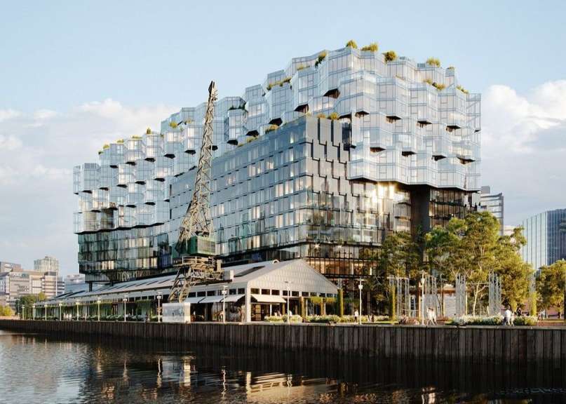 Ein großes Gebäude mit vielen Fenstern steht neben einem Fluss