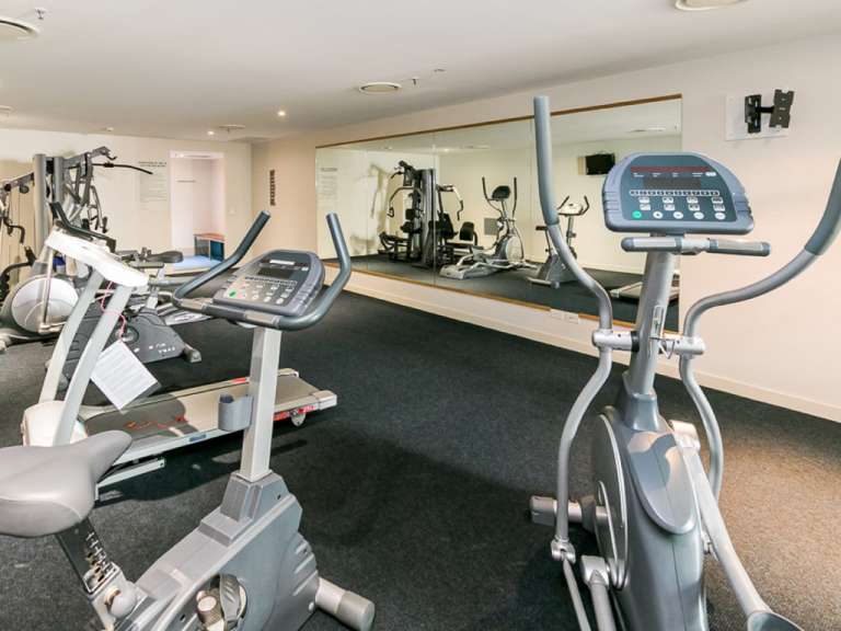 Ein Fitnessstudio mit vielen Geräten und einem großen Spiegel