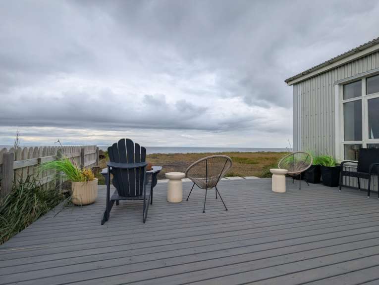 Ein Deck mit Stühlen und einem Tisch mit Blick auf das Meer