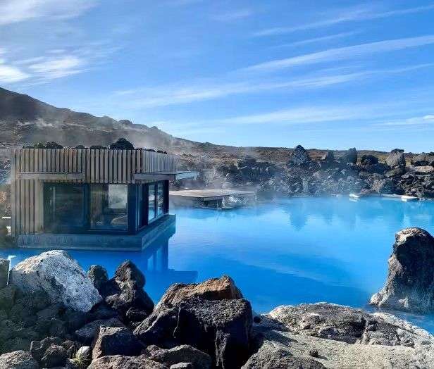Ein kleines Haus steht in der Mitte eines großen blauen Pools .
