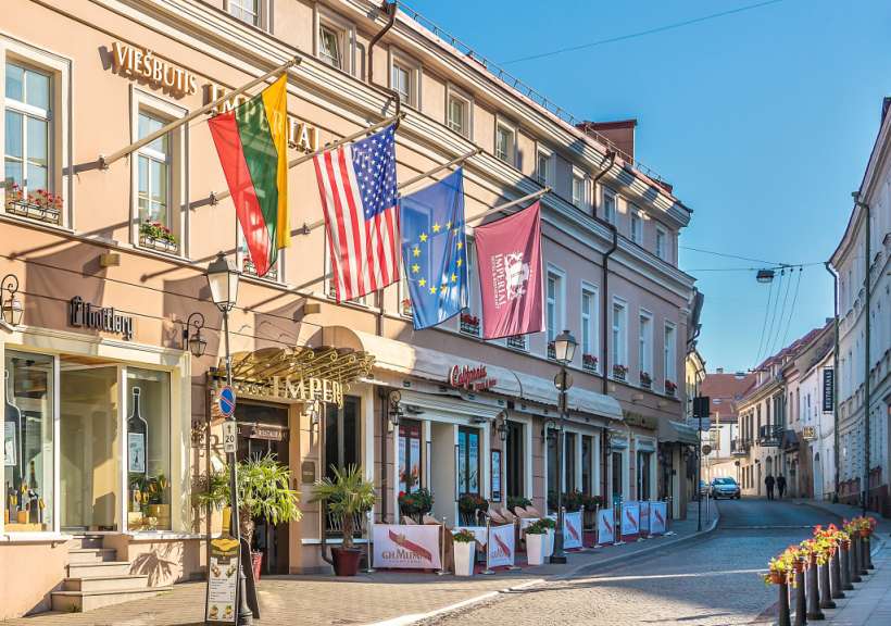 Auf diesem Bild ist eine Straße mit Gebäuden und Flaggen zu sehen.