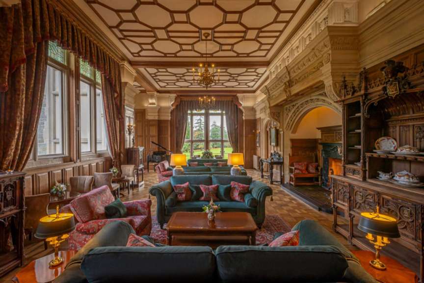 Dies ist ein luxuriöses Wohnzimmer mit Kamin, Klavier und antiken Möbeln.