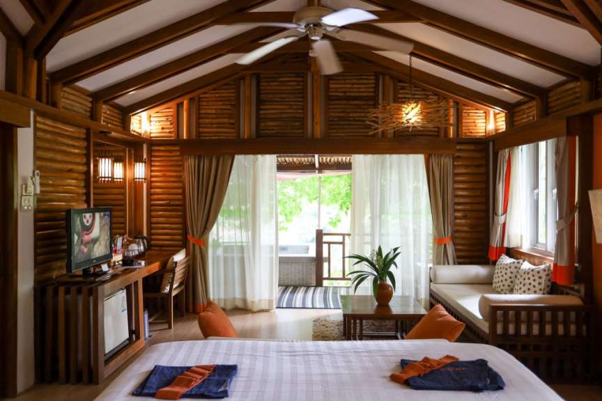 Ein Schlafzimmer mit Holzwänden und einer Decke mit sichtbaren Balken.