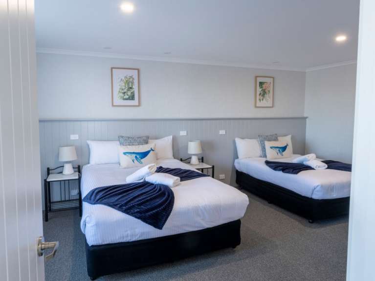 Ein Hotelzimmer mit zwei Betten und einer Dekoration von Blumen und Walen.