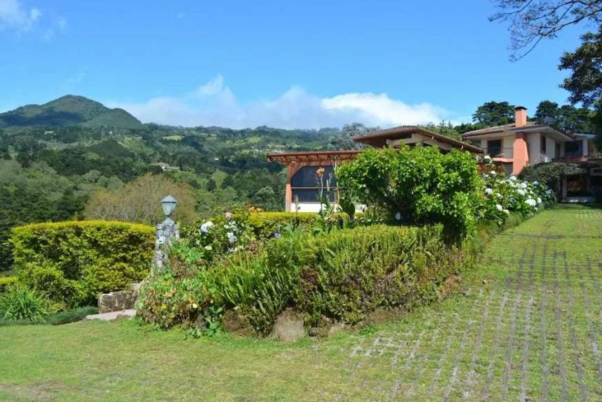 Ein malerisches Haus mit einem Garten und einer schönen Landschaft im Hintergrund.