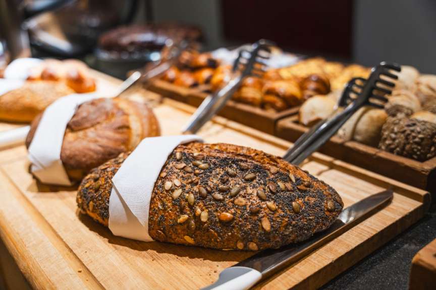 Auf diesem Bild ist ein Büffet mit verschiedenen Brotsorten und Gebäck zu sehen.