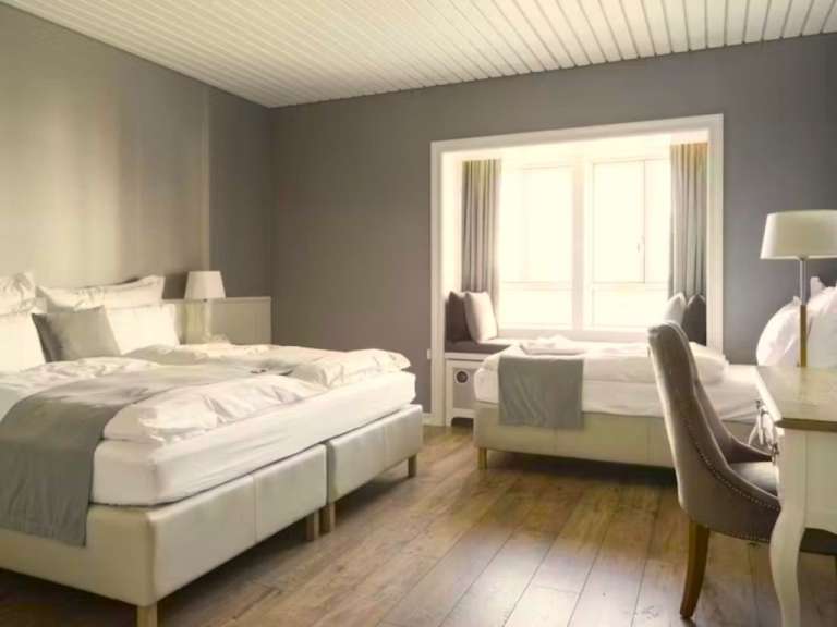 Ein Schlafzimmer mit zwei Betten und einem Fenster.