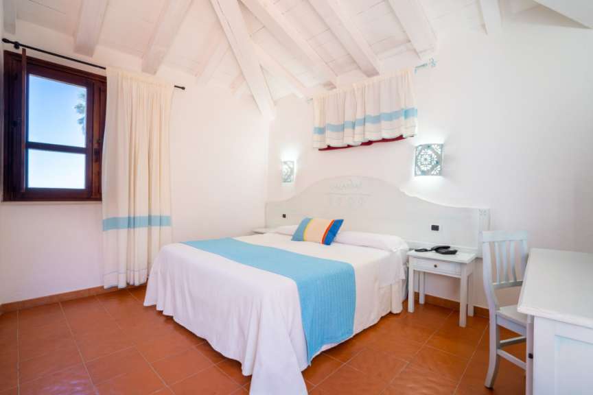 Ein Schlafzimmer mit einem Himmelbett und einem Schreibtisch mit Stuhl.