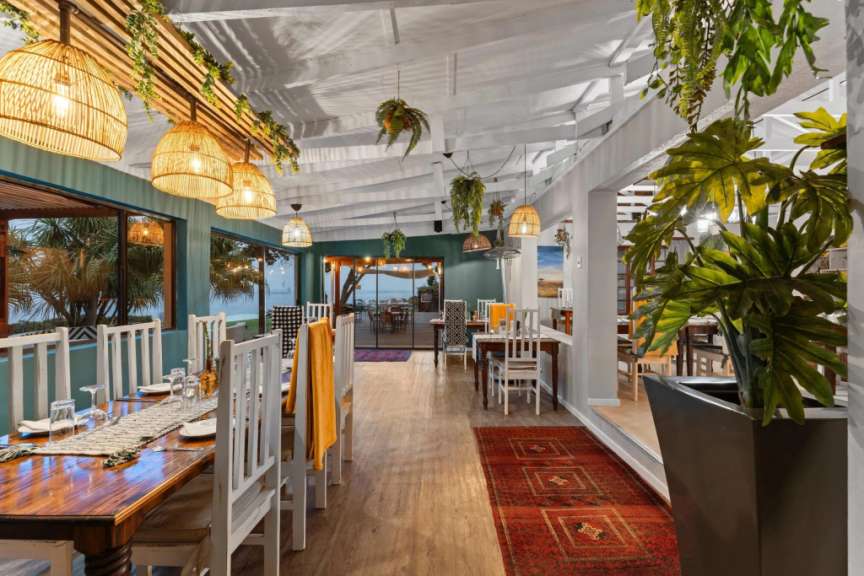 Dieses Bild zeigt das Innere eines Restaurants mit Blick auf das Meer.