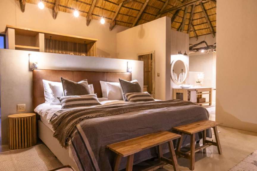 Ein luxuriöses Schlafzimmer mit Strohdach und einem großen Bett.