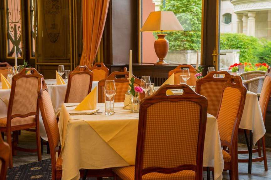 Ein gedeckter Tisch in einem Restaurant mit Holzsitzmöbeln und einer Nachttischlampe.