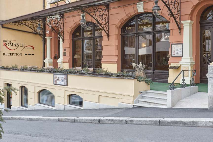 Das Bild zeigt die Fassade eines Hotels mit einem Restaurant und einer Rezeption.