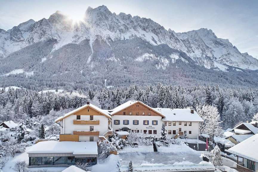 Verschneites Hotel vor Bergkulisse