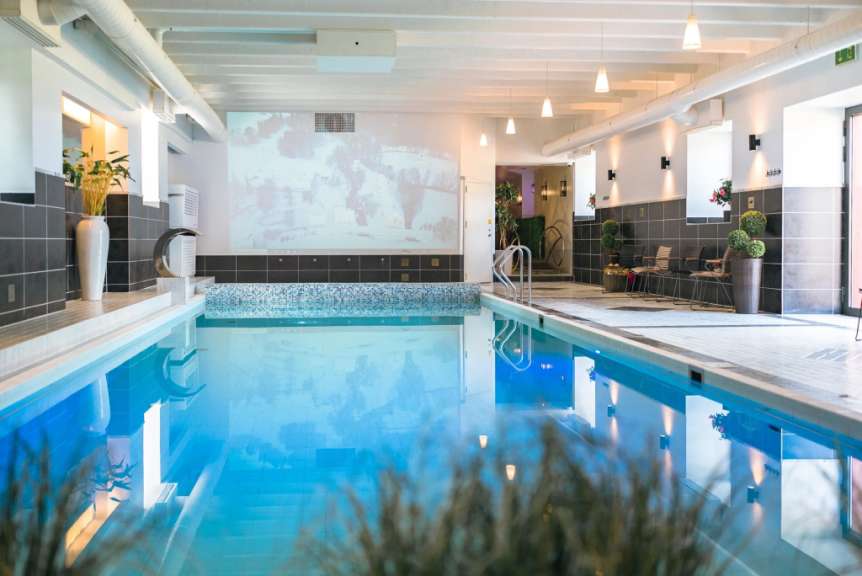 Das Foto zeigt ein Innenhallenbad mit einem rechteckigen Swimmingpool in einem Hotel in Estland.