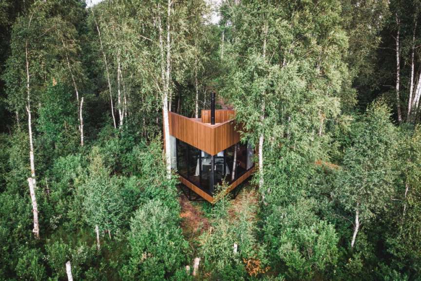 Eine moderne Naturvilla mit Glasfronten, eingebettet in einen dichten Birkenwald im Naturresort in Raplamaa.