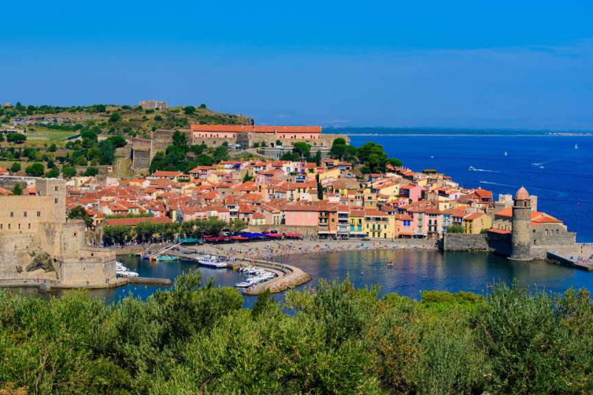 Blick auf Collioure in Frankreich mit der Küstenstadt, dem Schloss, dem Hafen und der Mittelmeerküste.