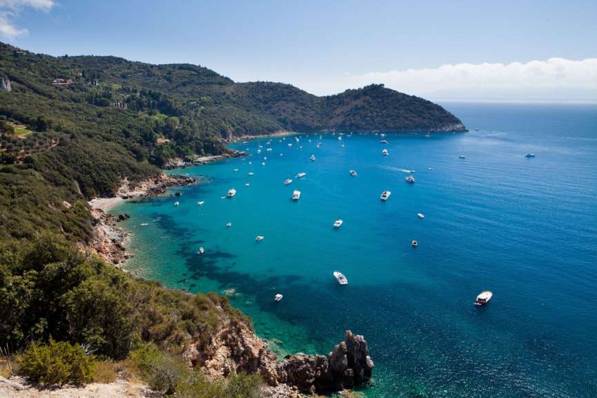 Eine Bucht mit vielen Booten und Bergen im Hintergrund