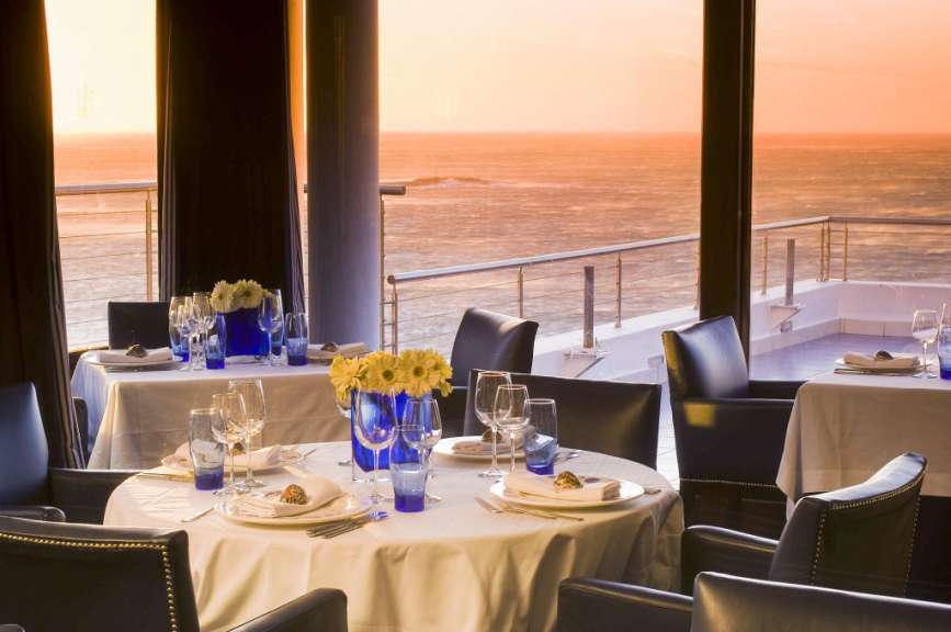 Tische und Stühle in einem Restaurant mit Blick auf das Meer