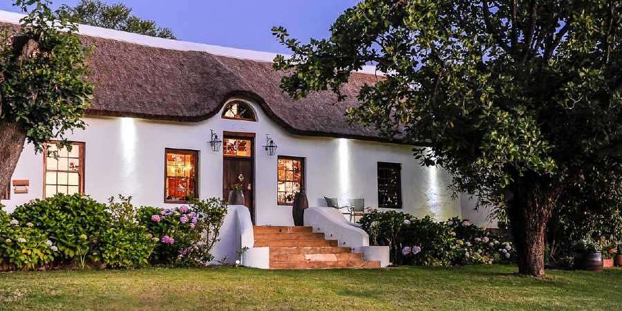 Ein weißes Haus mit strohdach und einer Treppe .