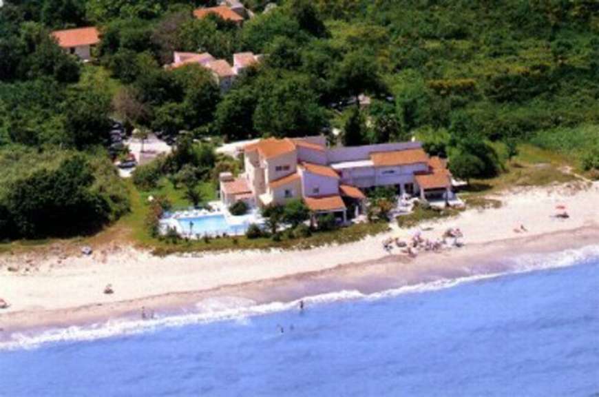 Eine Luftaufnahme eines Strandes mit einem großen Haus im Hintergrund