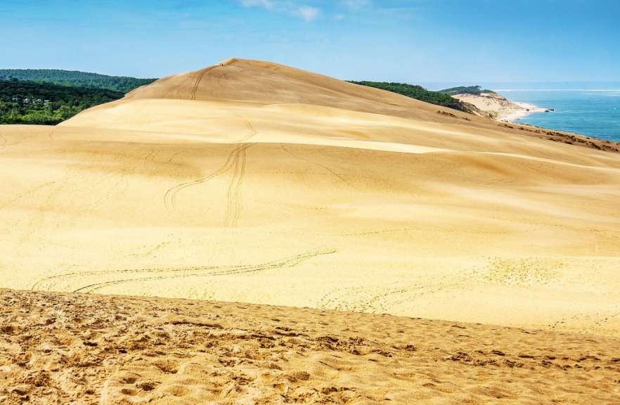 Ein großer sandiger Hügel mit Blick auf das Meer