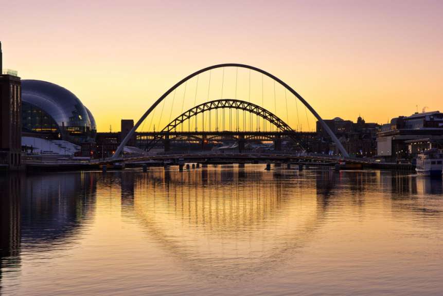 Eine Brücke über einen Fluss mit einem Gebäude im Hintergrund