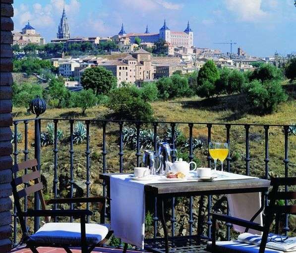 Ein Tisch und Stühle auf einem Balkon mit Blick auf eine Stadt