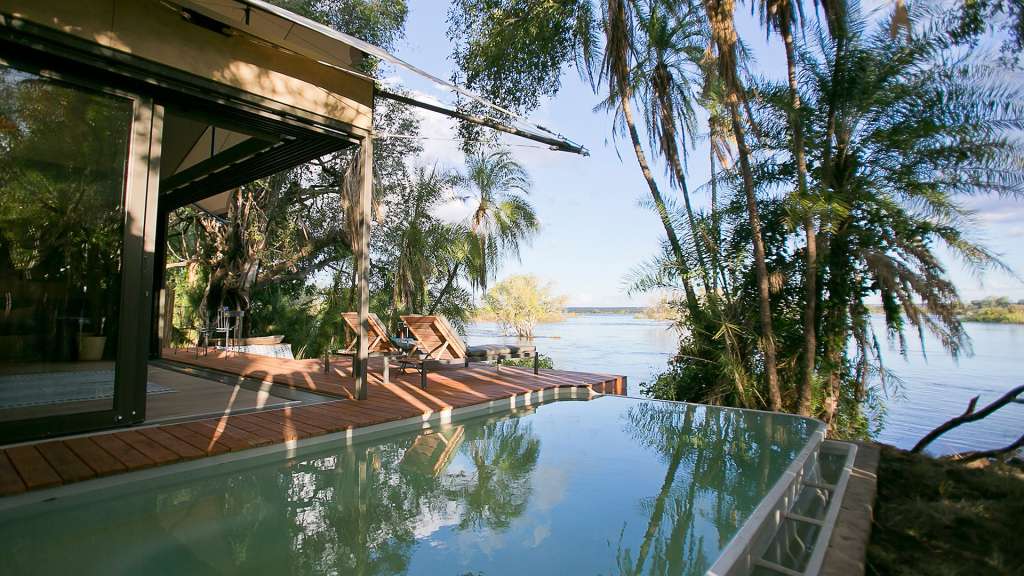 Ein Haus mit einem Infinity-Pool neben einem Fluss